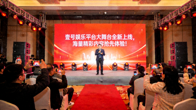 壹号娱乐平台发布会现场 - 明亮舞台上主持人正在介绍全新内容板块